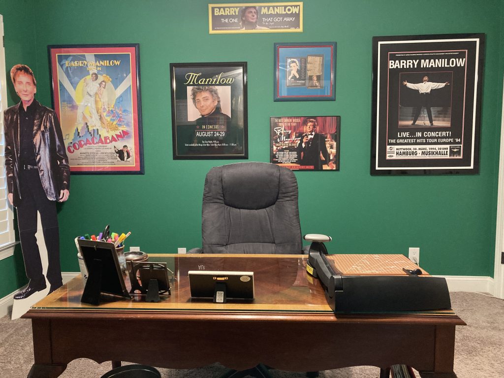 5 framed Barry Manilow posters, 1 framed set of tickets, and a Barry Manilow cardboard cut-out decorate my craft room.